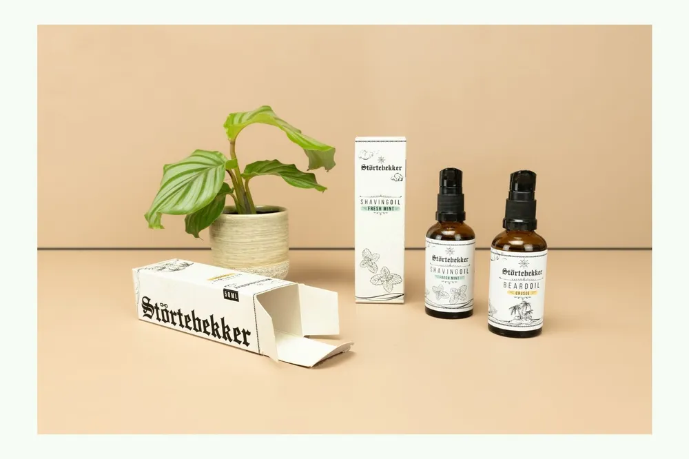 Bartölflaschen mit Kartonverpackungen und Pflanze Bartölflaschen mit Kartonverpackungen und Pflanze