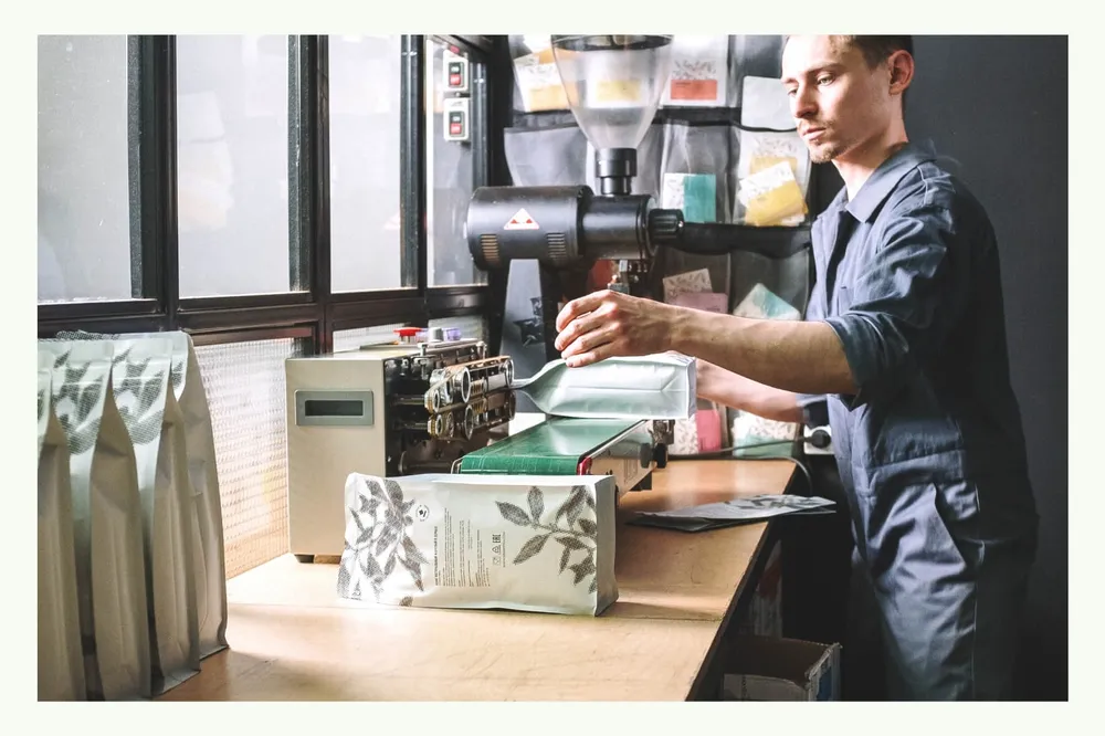 Uomo che utilizza una macchina per la lavorazione di scatole da imballaggio Uomo che utilizza una macchina per la lavorazione di scatole da imballaggio