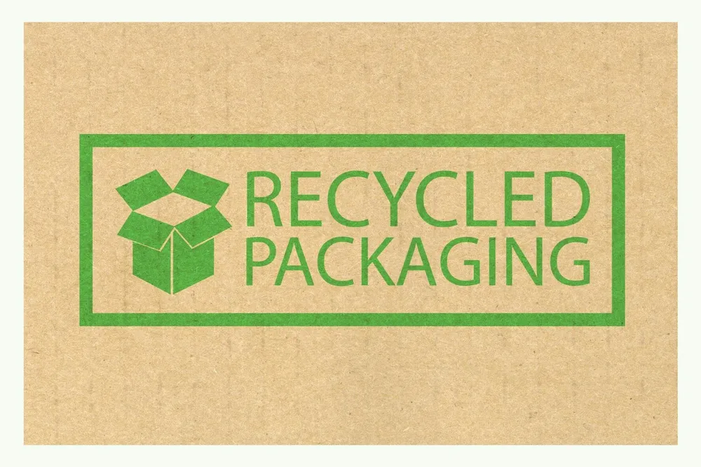 Green logo with the text Recycled Packaging on brown cardboard Green logo with the text Recycled Packaging on brown cardboard