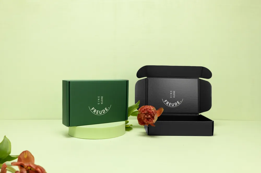 Scatole prodotto aperte in verde e nero su sfondo chiaro Scatole prodotto aperte in verde e nero su sfondo chiaro